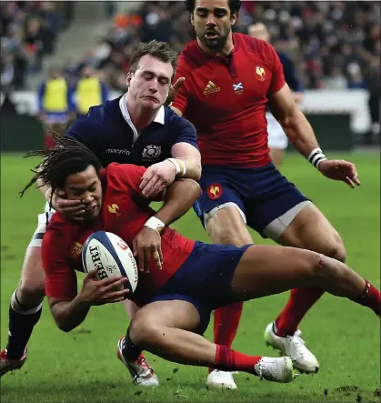  ??  ?? WRAPPED UP: Teddy Thomas of France is held by Scotland’s Stuart Hogg in Paris yesterday