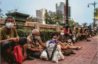  ?? Adam Dean / New York Times ?? Homeless people line up at a food distributi­on center in Bangkok. The gains the world was making in fighting poverty are now at grave risk as a result of the pandemic.