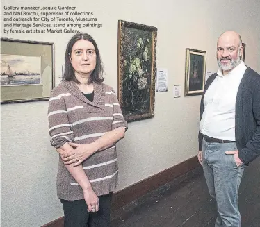  ?? ANDREW FRANCIS WALLACE TORONTO STAR ?? Gallery manager Jacquie Gardner and Neil Brochu, supervisor of collection­s and outreach for City of Toronto, Museums and Heritage Services, stand among paintings by female artists at Market Gallery.