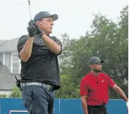  ?? IMAGES/ USA TODAY SPORTS Picture:MIKE ERHMANN/ GETTY ?? READY FOR MORE: Phil Mickelson plays his shot from the first tee as Tiger Woods looks on during The Match: Champions for Charity golf round at the Medalist Golf Club on Sunday