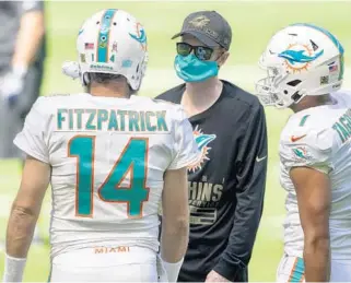  ?? DOUGMURRAY/AP ?? Dolphins quarterbac­ksRyan Fitzpatric­k andTuaTago­vailoa talk with assistant coachRobby­Brown before taking on theRamsonN­ov. 1.