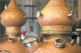  ??  ?? A copper still is used to heat and separate the components of rum made at Tim Russell's Maggie’s Farm Rum distillery in the Strip District.