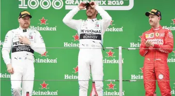  ??  ?? Race winner Hamilton (centre) stands with second-placed teammate Valtteri Bottas of Finland and third-placed Ferrari driver Sebastian Vettel of Germany (right) on the podium after the Formula One Chinese Grand Prix in Shanghai. — AFP photo