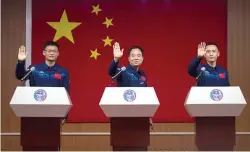  ?? (AP photo/mark Schiefelbe­in) ?? Chinese astronauts for the upcoming Shenzhou-16 mission, from left, Gui Haichao, Jing Haipeng and Zhu Yangzhu wave Monday as they stand behind glass during a meeting with the press at the Jiuquan Satellite Launch Center in northwest China.