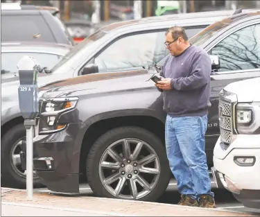  ?? Tyler Sizemore / Hearst Connecticu­t Media ?? Stamford’s Greg Fries pays for parking using the Park Mobile app at Columbus Park in downtown Stamford last week. Starting Jan. 1 a tax on metered parking will increase meter rates on downtown street spaces from $1.25 to $1.33. The city is struggling with how to collect the tax from meters, including for people who pay in cash and will no longer be able to drop in just quarters. Meters don’t take nickels and pennies, so motorists who don't want to use a credit card will be forced to overpay. Fries says he doesn't mind paying the 35 cent convenienc­e fee on the Park Mobile app, but is opposed to extra 8 cent tax upcoming.