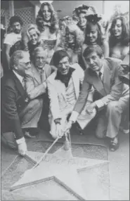  ?? FILE — THE ASSOCIATED PRESS ?? Chairman of the Board, Playboy Enterprise­s Inc., Hugh Hefner, center, receives a star on the Hollywood Walk of Fame in Los Angeles. Honorary Mayor of Hollywood, Monty Hall, right, holds the rope attached to the new star with Hefner.