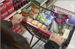  ?? AP photo ?? Jaqueline Benitez, who depends on California’s SNAP benefits to help pay for food, shops for groceries at a supermarke­t in Bellflower, Calif., on Feb. 13.