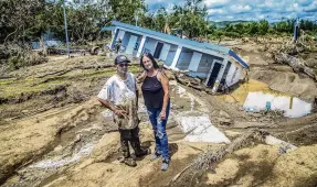  ?? PHOTO: TNS ?? Leida Rodriguez and Javier Castellano­s stand in front of their house that collapsed into a sinkhole after being flooded with water and mud during Hurricane Fiona at Villa Esperanza in Salinas, Puerto Rico.