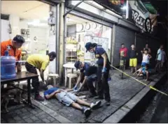  ?? CELIS/AFP NOEL ?? Police officers work at a crime scene, where an alleged drug dealer was killed during a police anti-drug operation, in Manila yesterday.