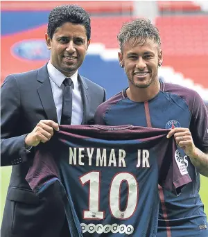  ?? Picture: Getty. ?? Neymar poses with his new colours, along with Paris Saint-Germain president Nasser Al-Khelaifi, after his record £198m move.