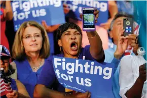  ??  ?? A HILLARY CLINTON supporter yells out with a picture of Donald Trump on her phone as Clinton speaks during a campaign stop in Fresno, California, on Saturday.