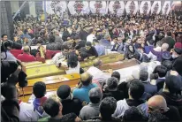  ?? Picture: AFP ?? ATROCITY: Egyptian Christians gather around and mourn by coffins during the late night funeral of the victims of a blast which killed worshipper­s attending Palm Sunday mass at the Mar Girgis Coptic Orthodox Church in the Nile Delta City of Tanta, 120km...