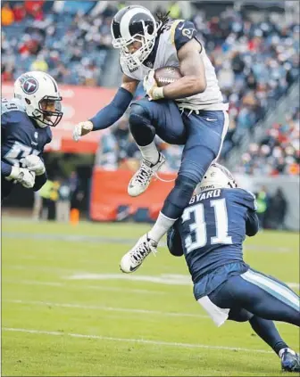  ?? WESLEY HITT Getty Images ?? LEAPING OVER Tennessee safety Kevin Byard last December, the Rams’ Todd Gurley has jumped over other running backs with a contract extension that reportedly guarantees him $45 million.