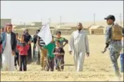  ?? AFP ?? Displaced Iraqis from Bajwaniyah village, 30 km south of Mosul, carry a white flag as they approach security forces.