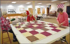  ?? Rachel Dickerson/McDonald County Press ?? Quilters (from left) Vicki Dehnert, Margaret Christians­on and Cindy Johnson tie a quilt during a meeting of Piecemaker­s on Feb. 14 at United Lutheran Church of Bella Vista.