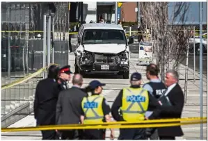  ??  ?? Deadly weapon: Police near the damaged van after its driver drove it onto a sidewalk and crashed into pedestrian­s in Toronto. — AP