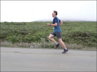  ?? Photo by Diana Haecker ?? OUT OF THE FOG— Tyler Rhodes runs past Newton Peak, shrouded in fog. Rhodes came in second place.