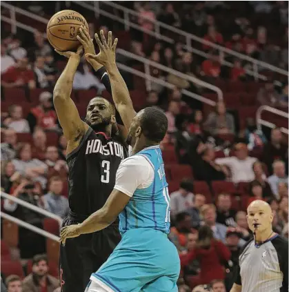  ?? Elizabeth Conley photos / Houston Chronicle ?? Rockets guard Chris Paul puts up a shot in the first quarter against the Hornets at Toyota Center on Wednesday night as the Rockets improved to a league-leading 22-4. Paul had game highs of 31 points and 11 assists.