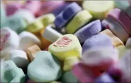  ?? CHARLES KRUPA — THE ASSOCIATED PRESS FILE ?? Colored “Sweetheart­s” candy is held in bulk prior to packaging at the New England Confection­ery Company in Revere, Mass. The bankrupt 171-year-old candy maker known for its chalky Necco Wafers and those little inscribed hearts that are everywhere on...