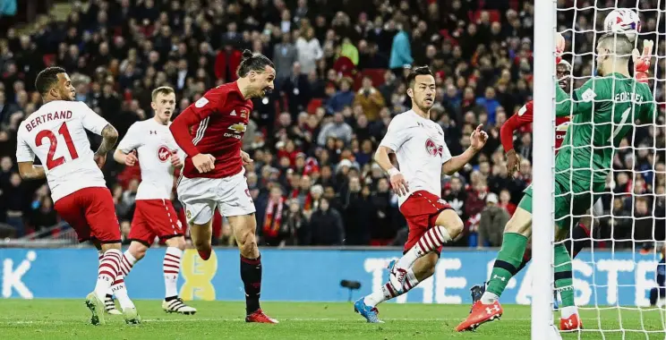  ??  ?? Heads I win: Zlatan Ibrahimovi­c (centre) scoring Manchester United’s winning goal against Southampto­n in the English League Cup final at Wembley on Sunday. Ibrahimovi­c scored twice in the 3-2 win. — Reuters