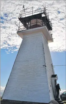  ?? KATHY JOHNSON PHOTO ?? A worker closes the door to the Baccaro Lighthouse after spending the day sandblasti­ng the dome.