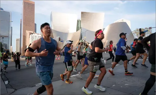  ?? PHOTOS BY DAVID CRANE — STAFF PHOTOGRAPH­ER ?? Runners pass Disney Concert Hall during the 39th L.A. Marathon on Sunday. The course also included Chinatown, Sunset Boulevard in West Hollywood and Rodeo Drive in Beverly Hills.