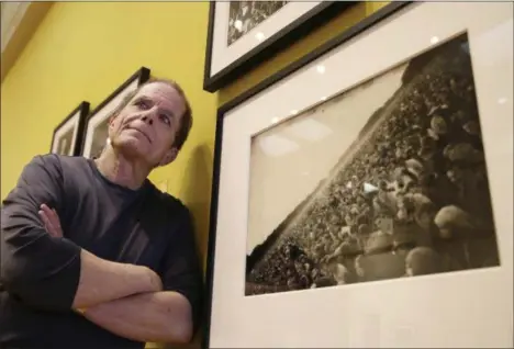  ?? THE ASSOCIATED PRESS ?? In this May 10 curator Dennis McNally stands by a photograph of the “Human Be-In” at the exhibit “On the Road to the Summer of Love” in the California Historical Society in San Francisco.