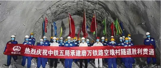 ??  ?? Showing commitment: Engineers of China Railway No. 5 Engineerin­g Group (CREC-5) posing for a group photo to celebrate the completion of the China-laos railway Ban Konlouang Tunnel in the Namor District of Oudomxay Province, Laos on April 29, 2020. The 9,020m Ban Konlouang Tunnel, in the Namor District of Oudomxay Province, some 400km north of Vientiane, goes through harsh geological conditions, which make its constructi­on a key bottleneck project of the railway. The China-laos Railway is a strategic docking project between the China-proposed BRI and Laos’ strategy to convert Laos from a landlocked country to a land-linked hub. — Xinhua