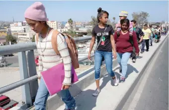  ?? GETTY IMAGES ?? Central American asylum- seekers walk to a legal counsellin­g meeting in Tijuana, Mexico, on Saturday.