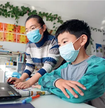  ??  ?? Liu Yelin, a third-grader in a residentia­l community in Zouping City, Shandong Province, and his mother are learning about Chinese ancient civilizati­on online at home on February 13, 2020.