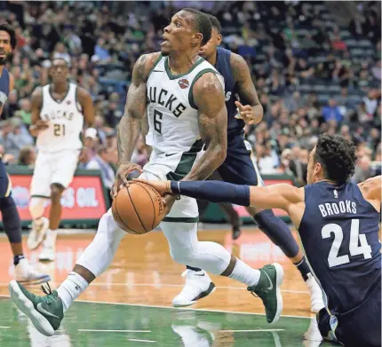  ?? MARK HOFFMAN/MILWAUKEE JOURNAL SENTINEL ?? Bucks guard Eric Bledsoe is fouled by Grizzlies forward Dillon Brooks as he drives toward the basket during the second half on Monday night at the BMO Harris Bradley Center.