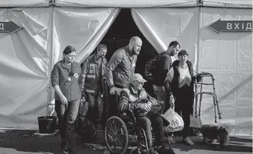  ?? NICOLE TUNG For The Washington Post ?? Civilian evacuees from the Russian-controlled city of Mariupol, including those from the besieged Azovstal steel factory, arrive Tuesday at a reception center for internally displaced people in Zaporizhzh­ia, Ukraine.