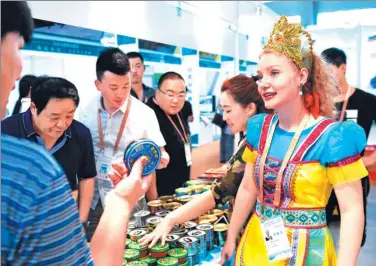  ?? WANG JIANWEI / XINHUA ?? Visitors to the China-Russia Expo in Harbin, capital of Heilongjia­ng province, check goods from Russia in June last year. The province has close trade ties with Russia, which it borders on.