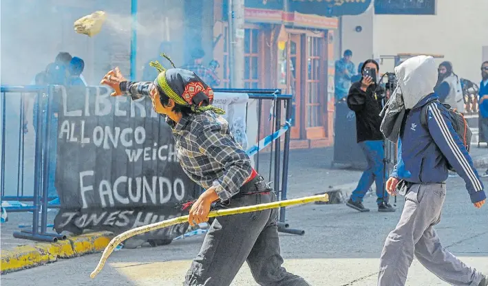  ?? MARIO QUINTEROS ?? Violencia. El mapuche Matías Santana arroja ayer una piedra contra el juzgado de Bariloche. Es el joven que dijo ver que Gendarmerí­a se llevaba a Santiago Maldonado.