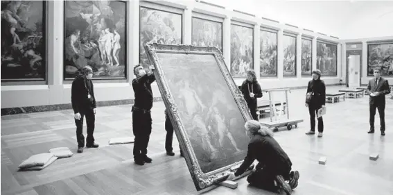  ?? DMITRY KOSTYUKOV/THE NEW YORK TIMES PHOTOS ?? Anthony van Dyck’s “Venus Asks Vulcan to Cast Arms for Her Son Aeneas” is moved by workers in January at the Louvre in Paris.