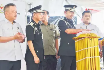  ??  ?? Mustafar cuts the ribbon to officially declare open the Immigratio­n Department office at the Federal Complex in Sri Aman as Ken (second left) and others look on.