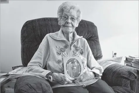  ?? COLIN CHISHOLM ?? Margaret Mitchell holds a photograph showing her late husband Earl and herself on their wedding day. The couple was married for over 65 years. On March 29, Margaret will celebrate her 100th birthday.