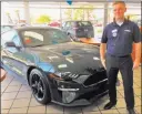  ?? Friendly Ford ?? Friendly Ford sales consultant Isaac Roberts is seen with the 2019 Mustang Bullitt in the showroom of the dealership at 660 N. Decatur Blvd.