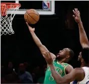  ?? AP ELISE AMENDOLA ?? Boston Celtics guard Kemba Walker (8) scores against Philadelph­ia 76ers center Joel Embiid in the first quarter of an NBA basketball game, Thursday, Dec. 12, in Boston.