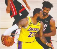  ?? KEVIN C. COX / GETTY IMAGES ?? Miami's Jimmy Butler, here defending L.A.'s LeBron
James, says Miami's confidence will “have to be at an all-time high” to rebound from a 3-1 series deficit.