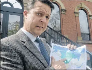  ?? MITCH MACDONALD/THE GUARDIAN ?? Brad Trivers holds up a map of the proposed amalgamati­on of North Shore, Pleasant Grove and Grand Tracadie following Wednesday’s question period. While the green area is the proposed new municipal boundaries, Trivers questioned why a 60-acre property...