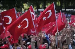  ?? LEFTERIS PITARAKIS, THE ASSOCIATED PRESS ?? Pro-government supporters wave Turkish flags Tuesday as they protest the attempted coup, in Istanbul. The turmoil likely means longer waits for refugees to leave.