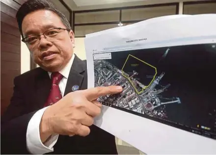  ?? PIC BY SHAHNAZ FAZLIE SHAHRIZAL ?? Penang Port Commission chairman Jeffrey Chew Gim Eam with a map of the Tanjung City Marina at a press conference in George Town yesterday. The marina was built at a cost of RM43 million in the early 2000s but has fallen into disuse.