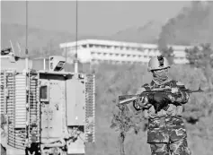  ??  ?? File photo shows Afghan security personnel standing guard as smoke billows from the Interconti­nental Hotel during a fight between gunmen and Afghan security forces in Kabul. — AFP photo