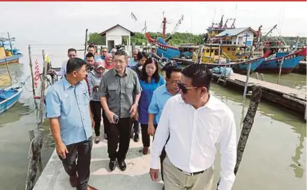  ?? PIC BY L. MANIMARAN ?? Agricultur­e and Agro-based Industry Minister Salahuddin Ayub (second from left) at a programme with fishermen in Pantai Remis, near Manjung, yesterday. With him is Pantai Remis assemblyma­n Wong May Ing (third from right).