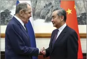  ?? RUSSIAN FOREIGN MINISTRY PRESS SERVICE VIA AP ?? Russian Foreign Minister Sergey Lavrov, left, and Chinese Foreign Minister Wang Yi shake hands prior to their talks in Beijing, China, on Tuesday.