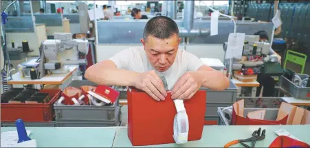  ?? ?? A Chinese worker crafts a high-end luxury handbag at a Chinese-owned factory in Florence, Italy.