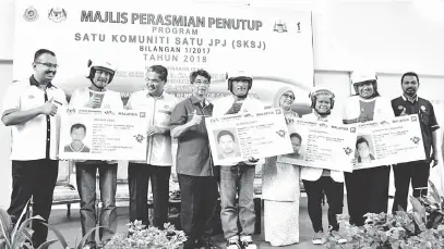  ?? — Gambar Bernama ?? ALBUM: Wan Ahmad Uzir (tiga kiri) bersama peserta program Satu Komuniti Satu JPJ (SKSJ) yang memperoleh­i lesen B2 pada majlis perasmiann­ya di Alor Gajah semalam.