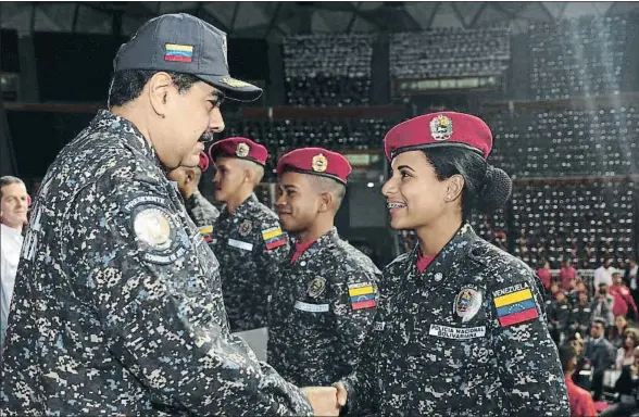  ?? HANDOUT / REUTERS ?? Nicolás Maduro felicitand­o a una nueva agente de policía durante una ceremonia de graduación del cuerpo en Caracas, el pasado 20 de diciembre