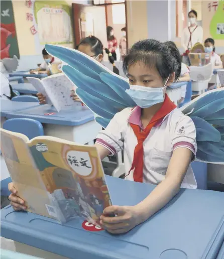  ?? PICTURE: AFP VIA GETTY ?? 0 Primary school pupils in Taiyuan, China, wear wings to help maintain social distancing